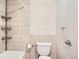 Bathroom featuring light colored tiles, toilet, and metal shelving at 3131 E Alameda Ave # 1503, Denver, CO 80209