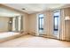 Bright bedroom featuring carpet floors, a wall mirror, two windows with city views, and neutral colored walls at 3131 E Alameda Ave # 1503, Denver, CO 80209
