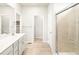 Bright bathroom featuring a glass enclosed shower, double vanity, and linen closet for ample storage at 24088 E Atlantic Pl, Aurora, CO 80018