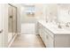 Bathroom view featuring a double vanity and a walk-in shower at 24088 E Atlantic Pl, Aurora, CO 80018