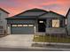 Charming single Gathering home with a two-car garage and stone accents at dusk at 24088 E Atlantic Pl, Aurora, CO 80018