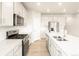 Bright kitchen boasts stainless steel appliances, white cabinets, and a spacious island, perfect for cooking and entertaining at 24088 E Atlantic Pl, Aurora, CO 80018