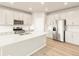 This kitchen features stainless steel appliances, an island, and sleek, white cabinetry at 24088 E Atlantic Pl, Aurora, CO 80018