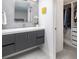 Contemporary bathroom featuring a gray vanity, closet and modern fixtures, and a unique tile backsplash at 7869 S Valentia St, Centennial, CO 80112