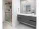 Modern bathroom featuring a sleek vanity with gray cabinetry, a frameless glass shower, and elegant tiling at 7869 S Valentia St, Centennial, CO 80112