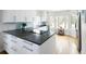 Modern kitchen featuring white cabinets, dark countertops, stainless steel appliances, and large windows at 7869 S Valentia St, Centennial, CO 80112