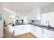 Stylish kitchen with white cabinets, granite countertops, hardwood floors, and modern lighting at 7869 S Valentia St, Centennial, CO 80112