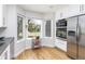 Bright kitchen with white cabinets, stainless steel appliances, hardwood floors, and bay window at 7869 S Valentia St, Centennial, CO 80112