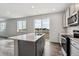 Bright kitchen featuring an island, stainless steel appliances, and sliding glass doors to the outside at 14378 Heritage Dr, Mead, CO 80504