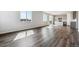 Open concept living room with wood-style flooring and a kitchen in the background at 14378 Heritage Dr, Mead, CO 80504