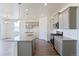 Open kitchen featuring stainless appliances, granite counters, gray cabinets, wood floors, and pendant lighting at 13457 Valentia St, Thornton, CO 80602