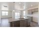 Island kitchen view showcases stainless dishwasher, granite counters, wood floors, and access to living area at 13457 Valentia St, Thornton, CO 80602