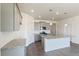Bright kitchen with stainless appliances, gray cabinetry, granite countertops, and wood flooring at 13457 Valentia St, Thornton, CO 80602