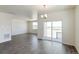 Spacious living room with wood flooring, large windows, and a sliding glass door leading to the outdoor patio at 13457 Valentia St, Thornton, CO 80602