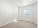 Bright bedroom featuring neutral carpet, white walls, and a window for natural light at 17305 E 91St Pl, Commerce City, CO 80022