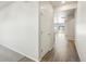 Hallway featuring hardwood floors, white walls, and natural light from the living area at 17305 E 91St Pl, Commerce City, CO 80022