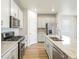 Modern kitchen featuring stainless steel appliances, white cabinetry, and granite countertops at 17305 E 91St Pl, Commerce City, CO 80022