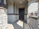 Welcoming front porch showing stone pillars, a modern black front door, and covered entry at 17305 E 91St Pl, Commerce City, CO 80022