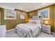Cozy bedroom features two windows, a white bed set, and neutral paint color at 6893 S High St, Centennial, CO 80122