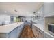 Open kitchen with large island, updated cabinets, stainless appliances, and hardwood floors at 6893 S High St, Centennial, CO 80122