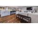 Open-concept kitchen featuring gray cabinets, stainless steel appliances, a breakfast bar, and hardwood flooring at 6893 S High St, Centennial, CO 80122