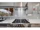 Modern kitchen with stainless steel range hood, subway tile backsplash, and ample counter space at 6893 S High St, Centennial, CO 80122