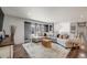 Open-concept living room with large sectional sofa, hardwood floors, and abundant natural light from large windows at 6893 S High St, Centennial, CO 80122