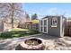 Backyard view featuring a shed with a decorative window, fire pit, and string lights for ambiance at 5698 E Greenwood Pl, Denver, CO 80222
