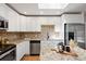 Bright kitchen with stainless appliances, center island, and tile backsplash at 5698 E Greenwood Pl, Denver, CO 80222