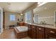 Bright bathroom with a large soaking tub, dual vanities with granite countertops, and tiled floors at 5285 La Quinta Cir, Elizabeth, CO 80107