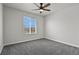 This bedroom boasts soft gray carpet, ample natural light from a window, and a ceiling fan at 5285 La Quinta Cir, Elizabeth, CO 80107