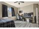 Cozy bedroom featuring a window, dark curtains, a bed, a ceiling fan, and a dedicated gaming space at 5285 La Quinta Cir, Elizabeth, CO 80107