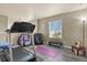 Dedicated exercise space with a treadmill, weights, and natural light from the window at 5285 La Quinta Cir, Elizabeth, CO 80107