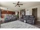 Comfortable living room featuring dual reclining couches, an area rug, a ceiling fan, and views into the kitchen at 5285 La Quinta Cir, Elizabeth, CO 80107