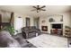 Open living room with a fireplace, TV, a fan, views into the entry, and comfortable reclining sofas at 5285 La Quinta Cir, Elizabeth, CO 80107