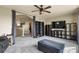Open concept living room featuring a television, shelving and adjacent room with modern ceiling fan at 5285 La Quinta Cir, Elizabeth, CO 80107
