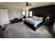 Spacious main bedroom with a ceiling fan, large bed, bench, and gray carpet at 5285 La Quinta Cir, Elizabeth, CO 80107