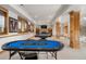 Spacious basement with a pool table, poker table, and wood pillars to the stairs at 35 Brookhaven Ln, Littleton, CO 80123