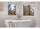 A soaking tub by two windows in a bright bathroom, complete with elegant decor at 35 Brookhaven Ln, Littleton, CO 80123
