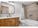A bathroom featuring wood cabinets, granite countertop, and a shower tub with shower curtain at 35 Brookhaven Ln, Littleton, CO 80123