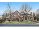 Charming Tudor-style home with stone facade, brown trim, meticulous landscaping and an inviting front entrance at 35 Brookhaven Ln, Littleton, CO 80123