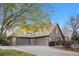 A Tudor-style home with stone accents, brown trim, three car garage and professionally landscaped front yard at 35 Brookhaven Ln, Littleton, CO 80123