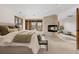 Main bedroom with stone fireplace, neutral carpet, and abundant light through several windows at 35 Brookhaven Ln, Littleton, CO 80123
