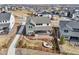 Aerial view of the home's backyard with a fire pit area, wooden fence, and covered porch, located in a suburban neighborhood at 6361 Kenzie Cir, Castle Pines, CO 80108