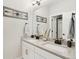 Bright bathroom featuring double sinks with bronze fixtures and decor, and large mirror at 6361 Kenzie Cir, Castle Pines, CO 80108