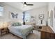 Bright bedroom with a butterfly art piece, cozy bed, and ample natural light from the windows at 6361 Kenzie Cir, Castle Pines, CO 80108
