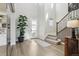 Bright entryway with hardwood floors, a staircase and large potted plant near the front door at 6361 Kenzie Cir, Castle Pines, CO 80108