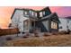Charming two-story home featuring a covered porch, lush landscaping, and a beautiful sunset backdrop at 6361 Kenzie Cir, Castle Pines, CO 80108