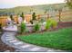 An inviting fire pit area with stone benches, lush greenery, and a well-maintained lawn, perfect for relaxing outdoors at 6361 Kenzie Cir, Castle Pines, CO 80108