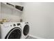 Bright laundry room features a modern washer and dryer, decorative tile floor and ample shelving at 6361 Kenzie Cir, Castle Pines, CO 80108